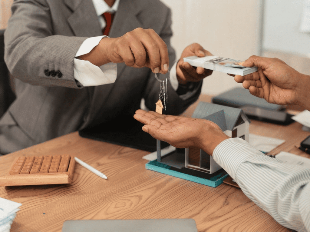 Entrega de llaves y fajo de billetes en efectivo en una transacción inmobiliaria o de alquiler ilegal. (Describe la acción clave para buscadores y lectores de pantalla).